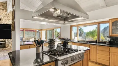a kitchen with a stove top oven next to some windows at Resort-Style Estate w Pool Game Room Tennis Court Near Wineries The Tennis Ranch by AvantStay in Escondido