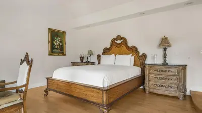 a bedroom with a wooden bed and a dresser at Resort-Style Estate w Pool Game Room Tennis Court Near Wineries The Tennis Ranch by AvantStay in Escondido