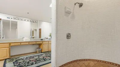 a bathroom with a shower with a tile wall at Resort-Style Estate w Pool Game Room Tennis Court Near Wineries The Tennis Ranch by AvantStay in Escondido