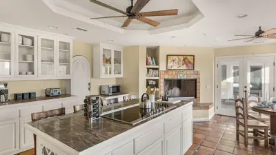 a kitchen with white cabinets and a ceiling fan at Private Estate w Pool Hot Tub Fire Pit Near Encinitas The Ranch by AvantStay in Escondido