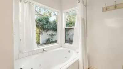 a white bath tub in a bathroom with a window at Private Estate w Pool Hot Tub Fire Pit Near Encinitas The Ranch by AvantStay in Escondido