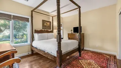 a bedroom with a four poster bed and a window at Two Estates w Pools Hot Tubs Game Rooms Valley Views Tennis Court Near Beaches Wineries in Escondido