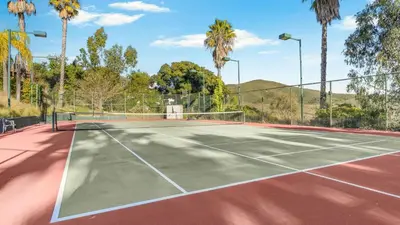a tennis court with palm trees in the background at Two Estates w Pools Hot Tubs Game Rooms Valley Views Tennis Court Near Beaches Wineries in Escondido