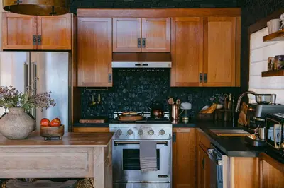 a kitchen with wooden cabinets and a stove top oven at Wild Moon Ranch with Pickleball, Cedar Tub, Views in Julian