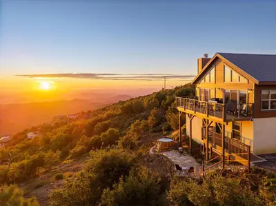 a house on a hill with the sunset in the background at Wild Moon Ranch with Pickleball, Cedar Tub, Views in Julian