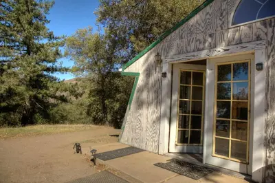 a dog sitting outside of a building with a door at Group Bunkhouse Sleeps 12 Mountain Views in Palomar Mountain
