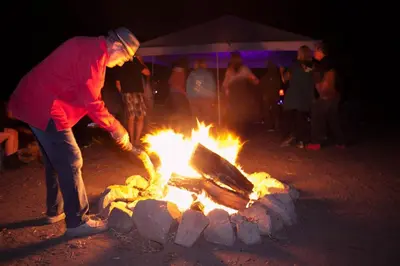a man standing next to a bonfire at night at Group Bunkhouse Sleeps 12 Mountain Views in Palomar Mountain