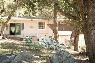 two chairs and a hammock in front of a house at Harrison Serenity Ranch - Groups over 50 in Palomar Mountain