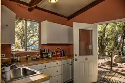 a kitchen with a sink and a door to a patio at Harrison Serenity Ranch - Groups over 50 in Palomar Mountain