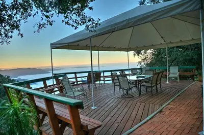 a deck with a table and chairs and an umbrella at Cozy Rustic Mountain Home with Breathtaking views in Palomar Mountain