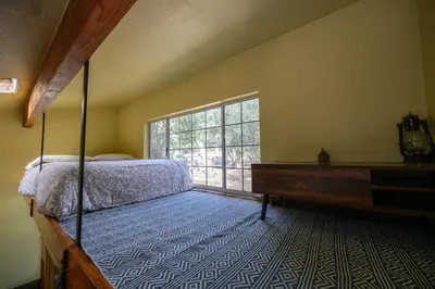 a bedroom with a bed and a large window at Cozy Rustic Mountain Home with Breathtaking views in Palomar Mountain