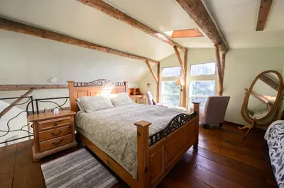 a bedroom with a bed and a dresser and windows at Cozy Rustic Mountain Home with Breathtaking views in Palomar Mountain