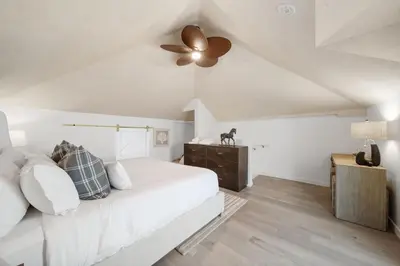a bedroom with a white bed and a ceiling fan at Terrace Views at La Jolla Cove in San Diego