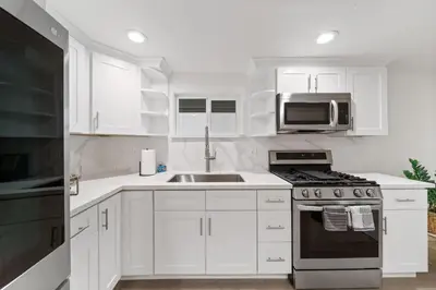 a white kitchen with a sink and a microwave at Terrace Views at La Jolla Cove in San Diego