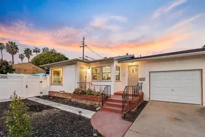 a house with a garage and a fence at Tourmaline Beach Cottage North -Steps to Ocean, AC in San Diego