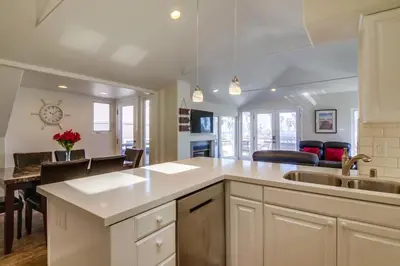 a kitchen with a sink and a dining room at Stunning beach home located between bay and beach with Ocean View Patio in San Diego