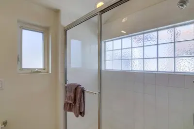 a bathroom with a shower with a glass door at Stunning beach home located between bay and beach with Ocean View Patio in San Diego