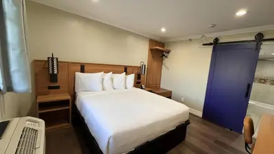 a bedroom with a large bed and a blue door at Border Plaza Hotel in San Diego