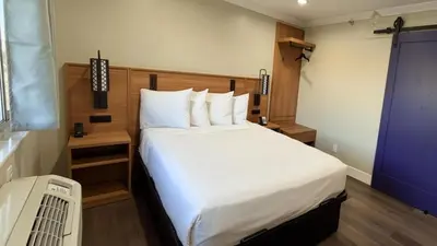 a bedroom with a large white bed in a room at Border Plaza Hotel in San Diego