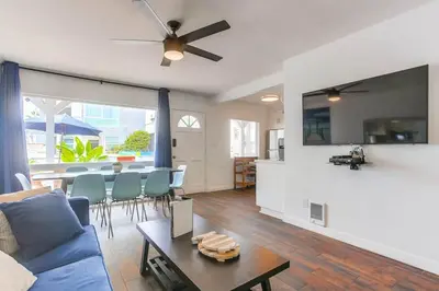 a living room with a blue couch and a table at South Shore Dream with Ocean View, Large Patio, BBQ in San Diego