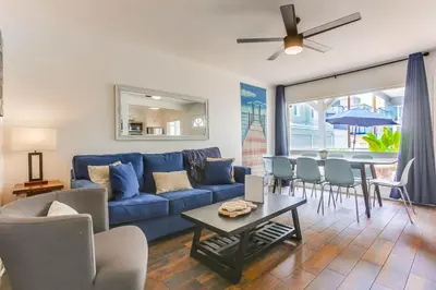 a living room with a blue couch and a table at South Shore Dream with Ocean View, Large Patio, BBQ in San Diego
