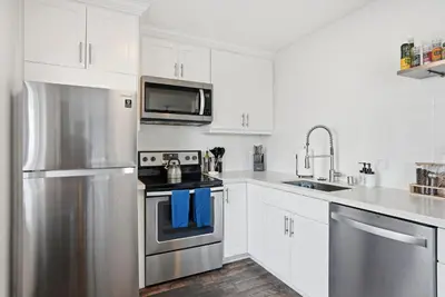 a kitchen with white cabinets and stainless steel appliances at South Shore Dream with Ocean View, Large Patio, BBQ in San Diego