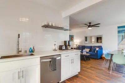 a kitchen with white cabinets and a living room at South Shore Dream with Ocean View, Large Patio, BBQ in San Diego