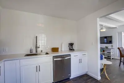 a kitchen with white cabinets and a stainless steel dishwasher at South Shore Gem with Ocean View, Patio, BBQ in San Diego