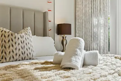 a bedroom with a bed with towels on it at Luxury Stay with Pool, Spa, Fire Pit, Outdoor Lounge & Stunning Ocean Views, Encinitas Retreat in Encinitas