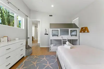 a white bedroom with a bed and a dresser at Luxury Stay with Pool, Spa, Fire Pit, Outdoor Lounge & Stunning Ocean Views, Encinitas Retreat in Encinitas