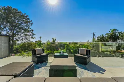 a patio with two couches and a table and chairs at Luxury Stay with Pool, Spa, Fire Pit, Outdoor Lounge & Stunning Ocean Views, Encinitas Retreat in Encinitas