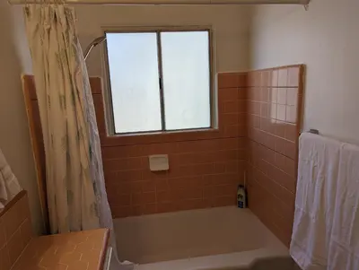 a bathroom with a bath tub and a window at Large 3 Bedroom near everything in San Diego in San Diego