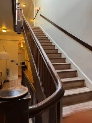 a staircase in a building with a wooden railing at Walk everywhere heart Gaslamp in San Diego