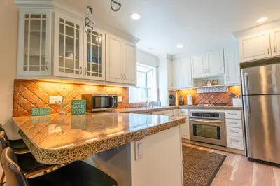 a kitchen with white cabinets and a granite counter top at Mission Casa Del Mar in San Diego