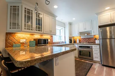 a kitchen with white cabinets and a granite counter top at Mission Casa Del Mar in San Diego