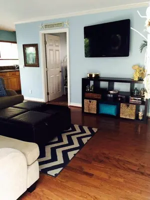a living room with a couch and a flat screen tv at Get Your Vitamin Sea! Steps to beach! Fire pit! in Newport Beach