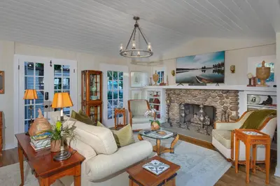 a living room with a couch and a fireplace at Seahorse Cottage in Secret Garden Sanctuary in San Diego
