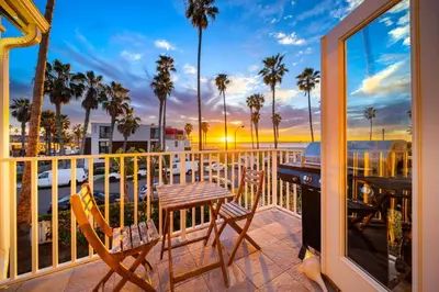 a balcony with two chairs and a table with a view of the ocean at Huge Beach Views Starfish Cottage Ocean Beach in San Diego