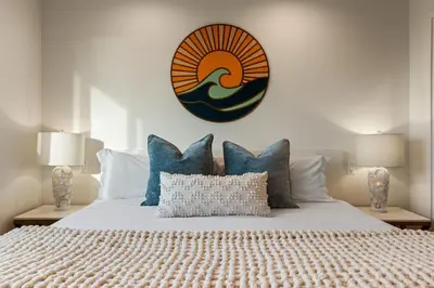 a bedroom with a large bed with blue pillows at Huge Beach Views Starfish Cottage Ocean Beach in San Diego