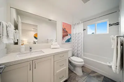 a white bathroom with a sink and a toilet at Huge Beach Views Starfish Cottage Ocean Beach in San Diego