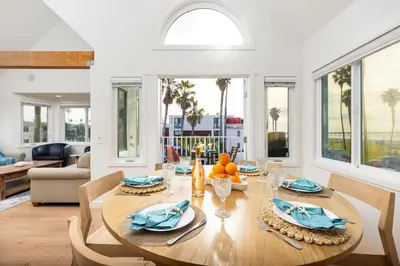 a dining room with a table and chairs and a living room at Huge Beach Views Starfish Cottage Ocean Beach in San Diego