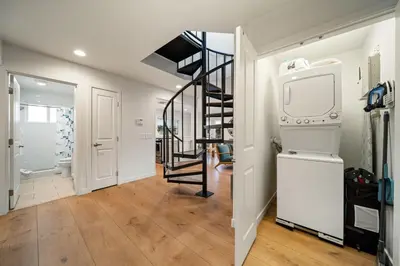 a living room with a spiral staircase and a tv at Stunning OB Ocean View Stay in San Diego