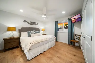 a bedroom with a bed and a table and a window at Ocean Beach Cottage with Views in San Diego