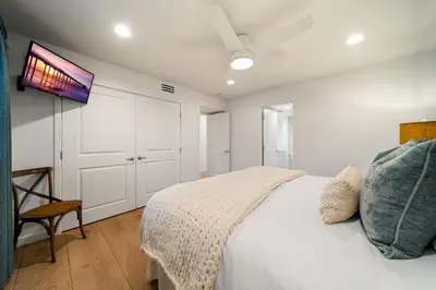 a bedroom with a bed with a tv on the wall at Ocean Beach Cottage with Views in San Diego