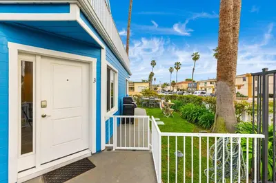 a blue house with a white door and a porch at Ocean Beach Cottage with Views in San Diego