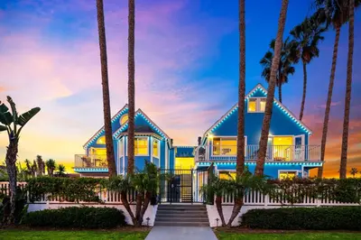 a blue and yellow house with palm trees at Ocean Beach Cottage with Views in San Diego