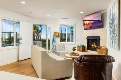 a living room with a couch and a fireplace at Ocean Beach Cottage with Views in San Diego