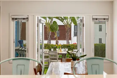 a dining room with a table and chairs on a patio at OB Cottage Beach Views in San Diego