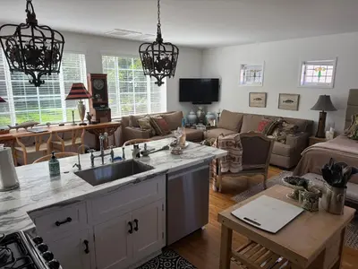 a kitchen with a sink and a living room at La Jolla Carriage House in San Diego