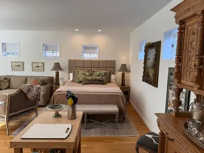 a bedroom with a bed and a couch and a table at La Jolla Carriage House in San Diego
